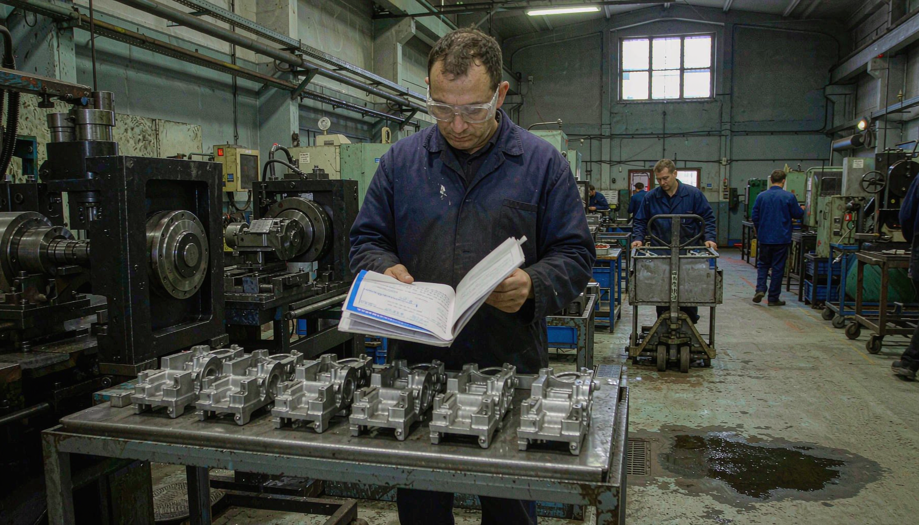 Buyer reviewing cast parts on a foundry floor in China