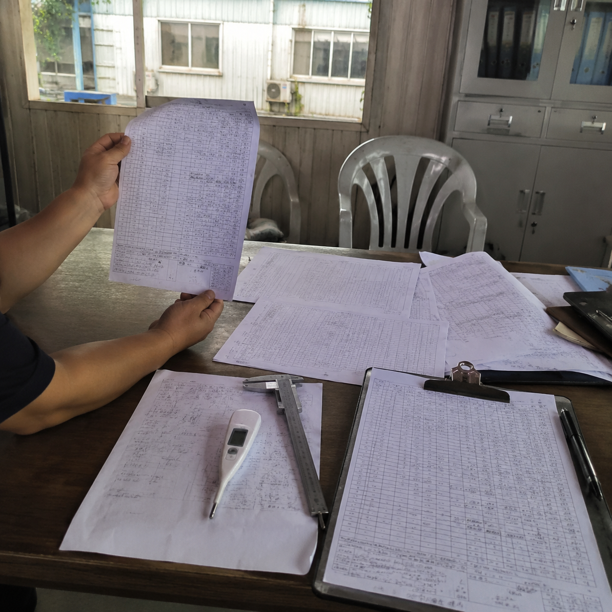Inspection reports and measuring tools on a desk in a Chinese office